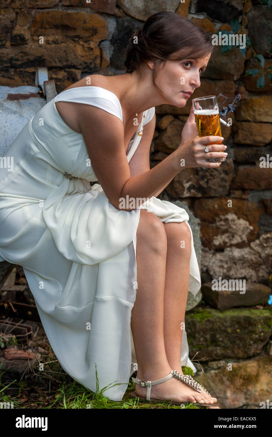 Bride resting alone Woman drinking beer smoking cigarette Stock Photo