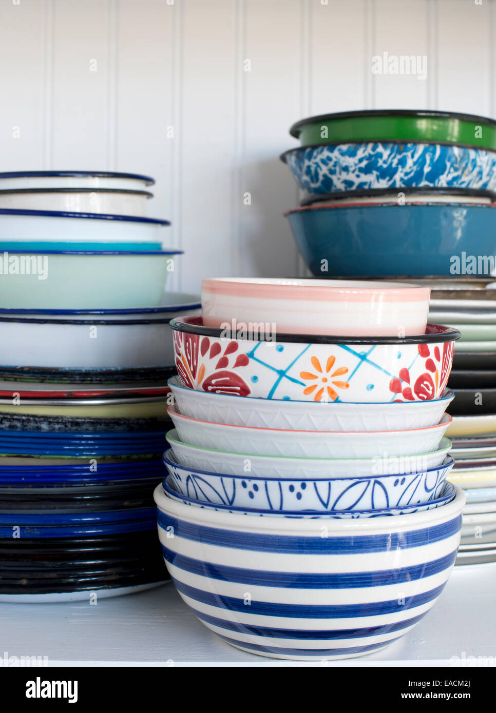 Pile of old dishes and bowls on a white shelf Stock Photo