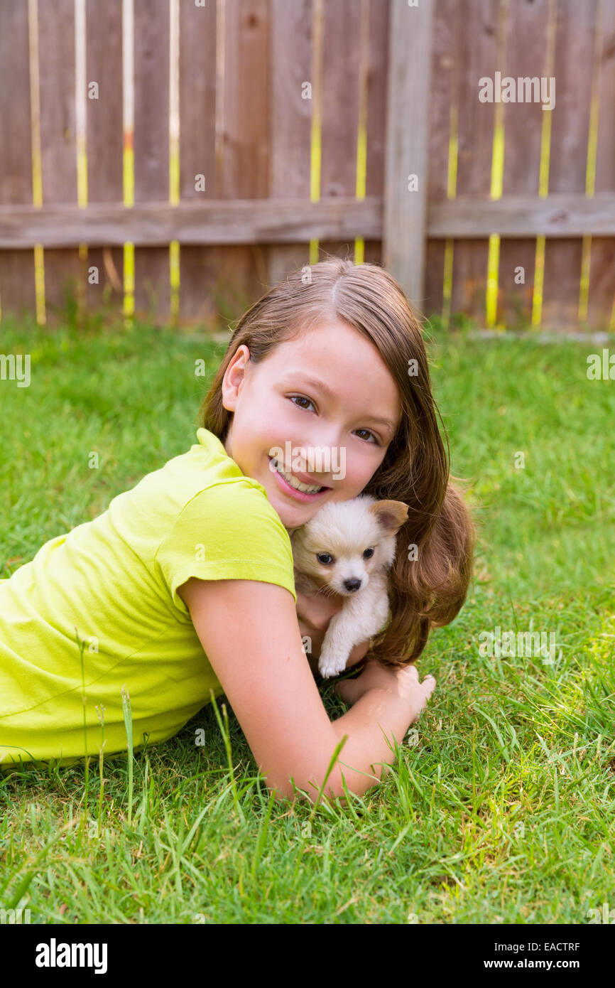 kid girl and puppy dog happy playing with chiuahua pet lying in ...
