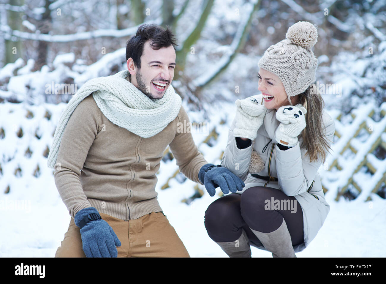 Happy couple laughing together in winter snow outdoors Stock Photo