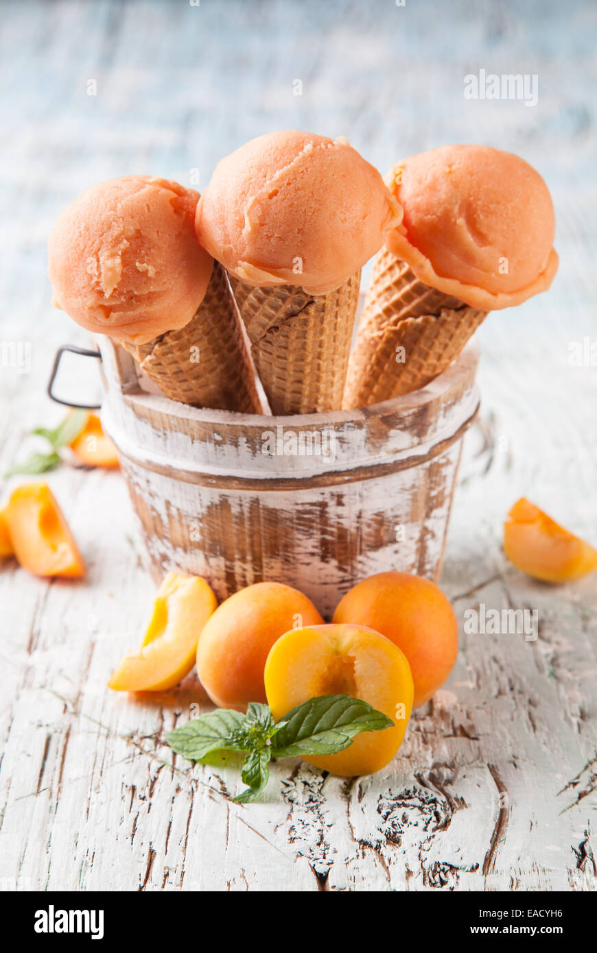 Studio photo of ice cream scoops in waffle cones. Served on wooden ...