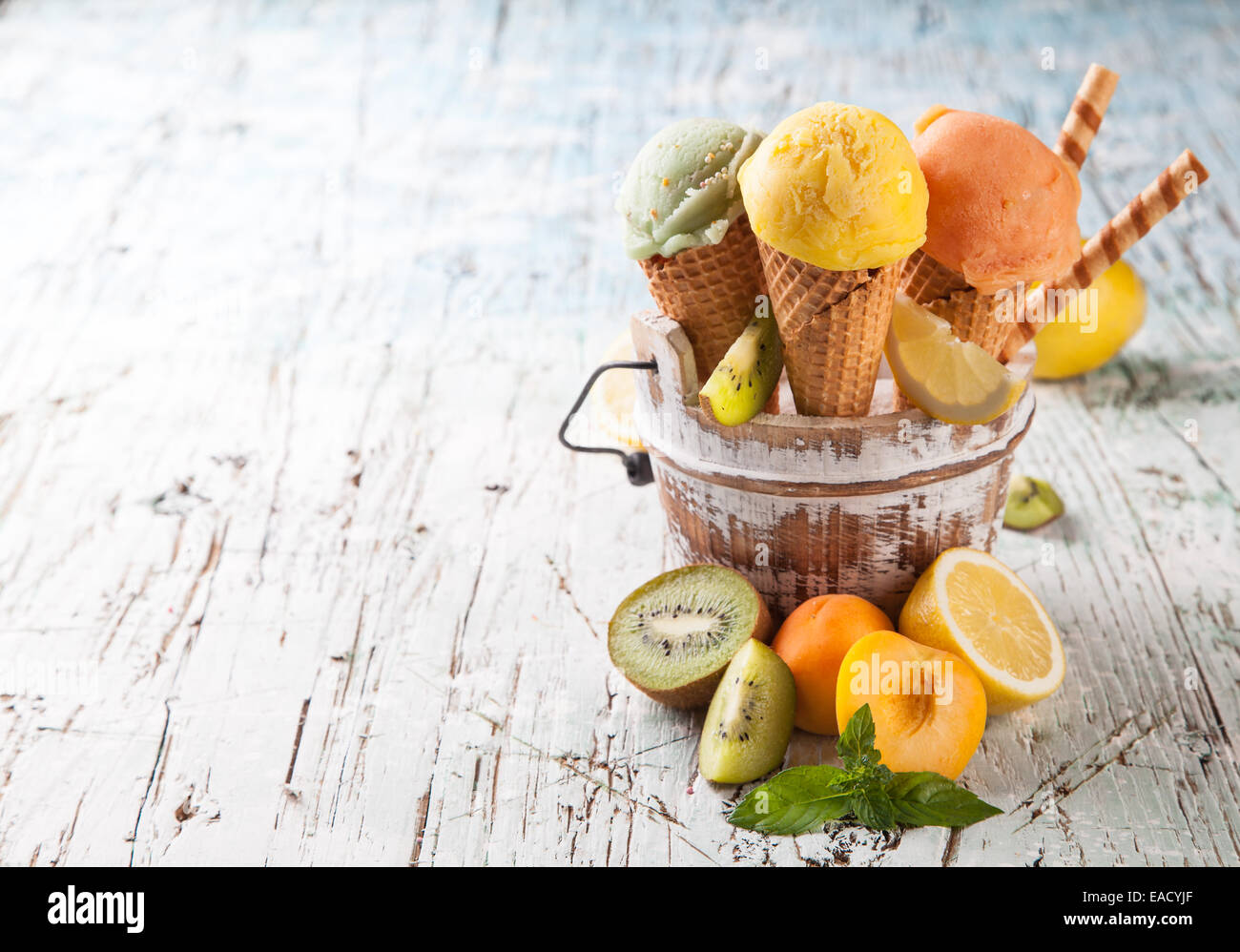 Studio photo of ice cream scoops in waffle cones. Served on wooden ...