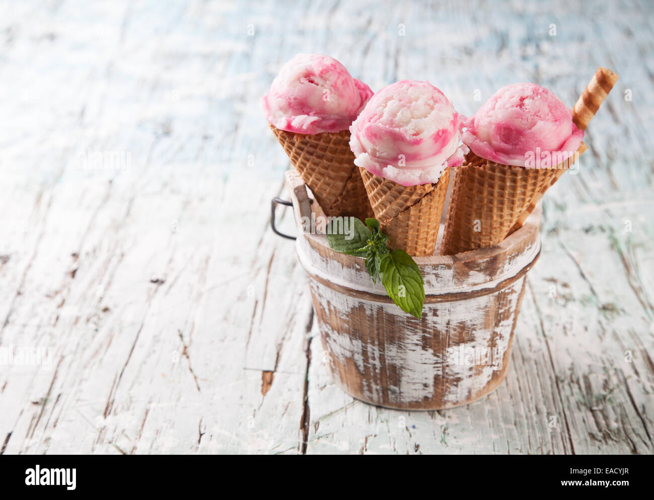 Studio photo of ice cream scoops in waffle cones. Served on wooden ...