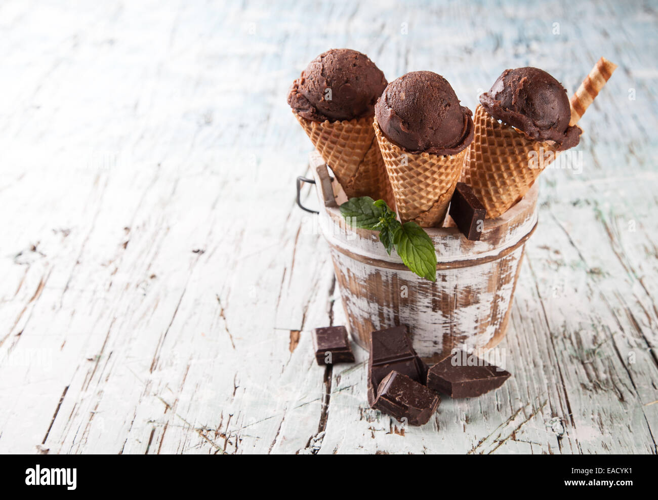Studio photo of ice cream scoops in waffle cones. Served on wooden ...