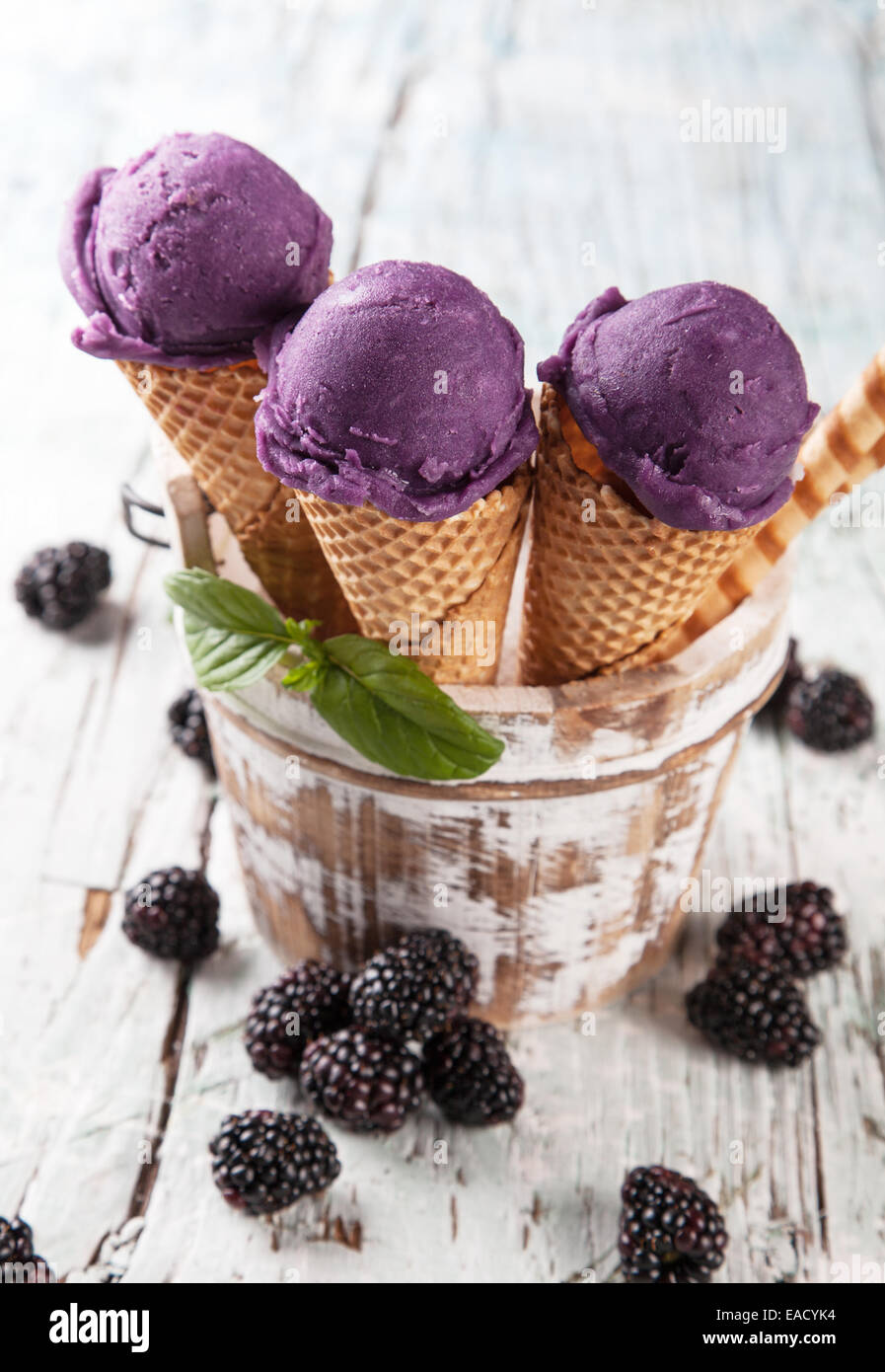 Studio photo of ice cream scoops in waffle cones. Served on wooden ...
