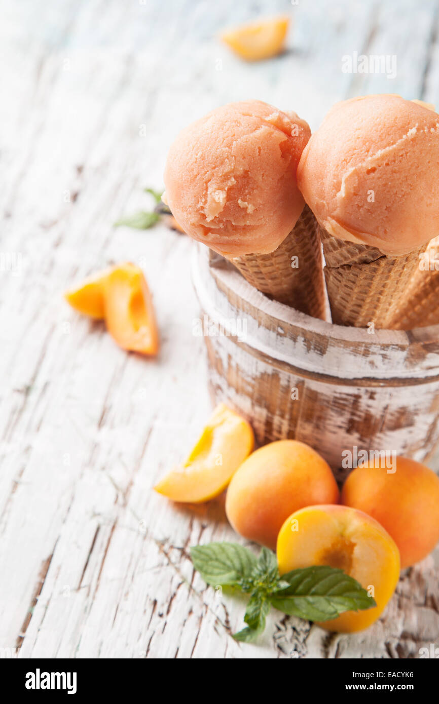 Studio photo of ice cream scoops in waffle cones. Served on wooden ...