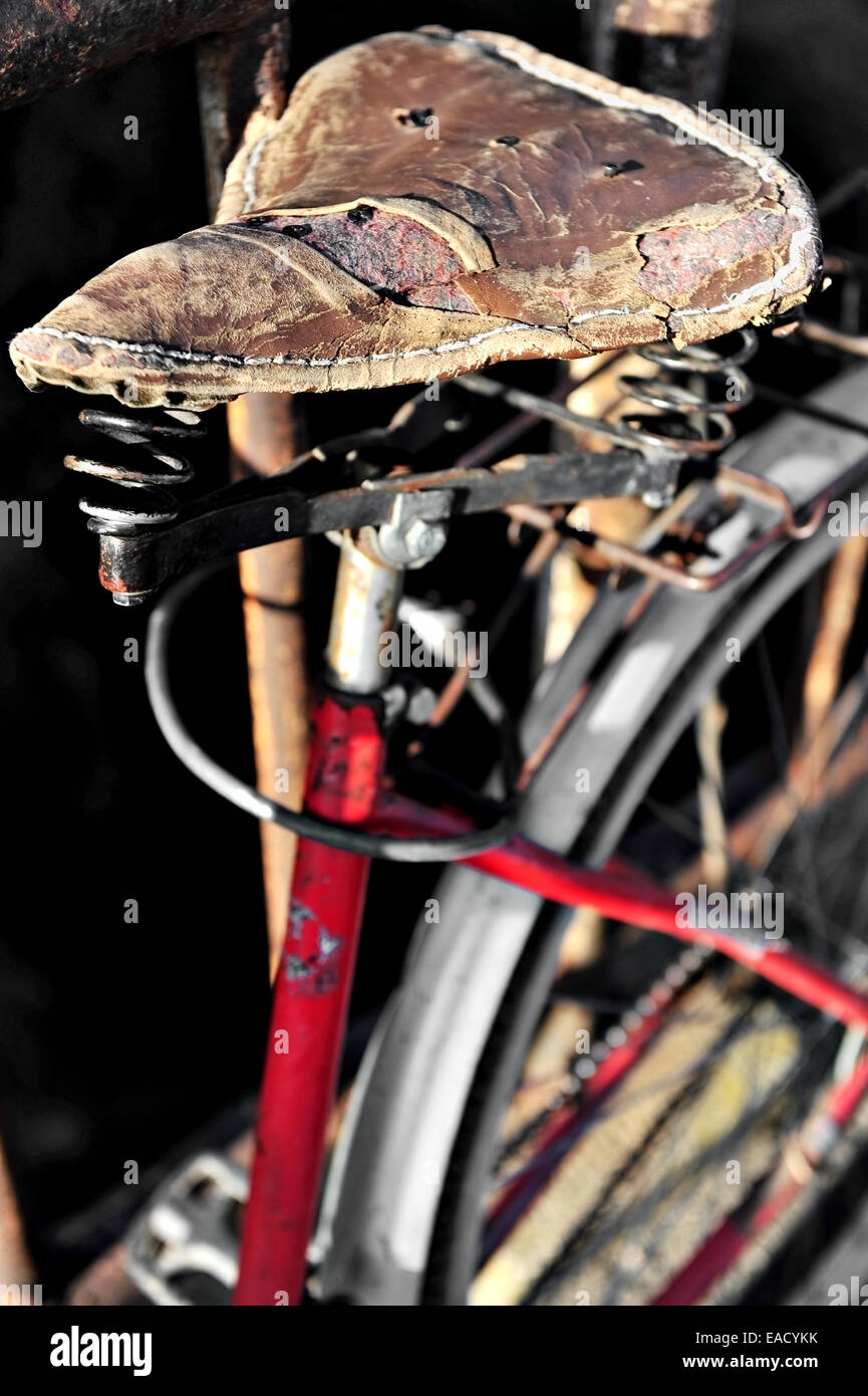 Detail with a torn vintage leather bicycle saddle Stock Photo
