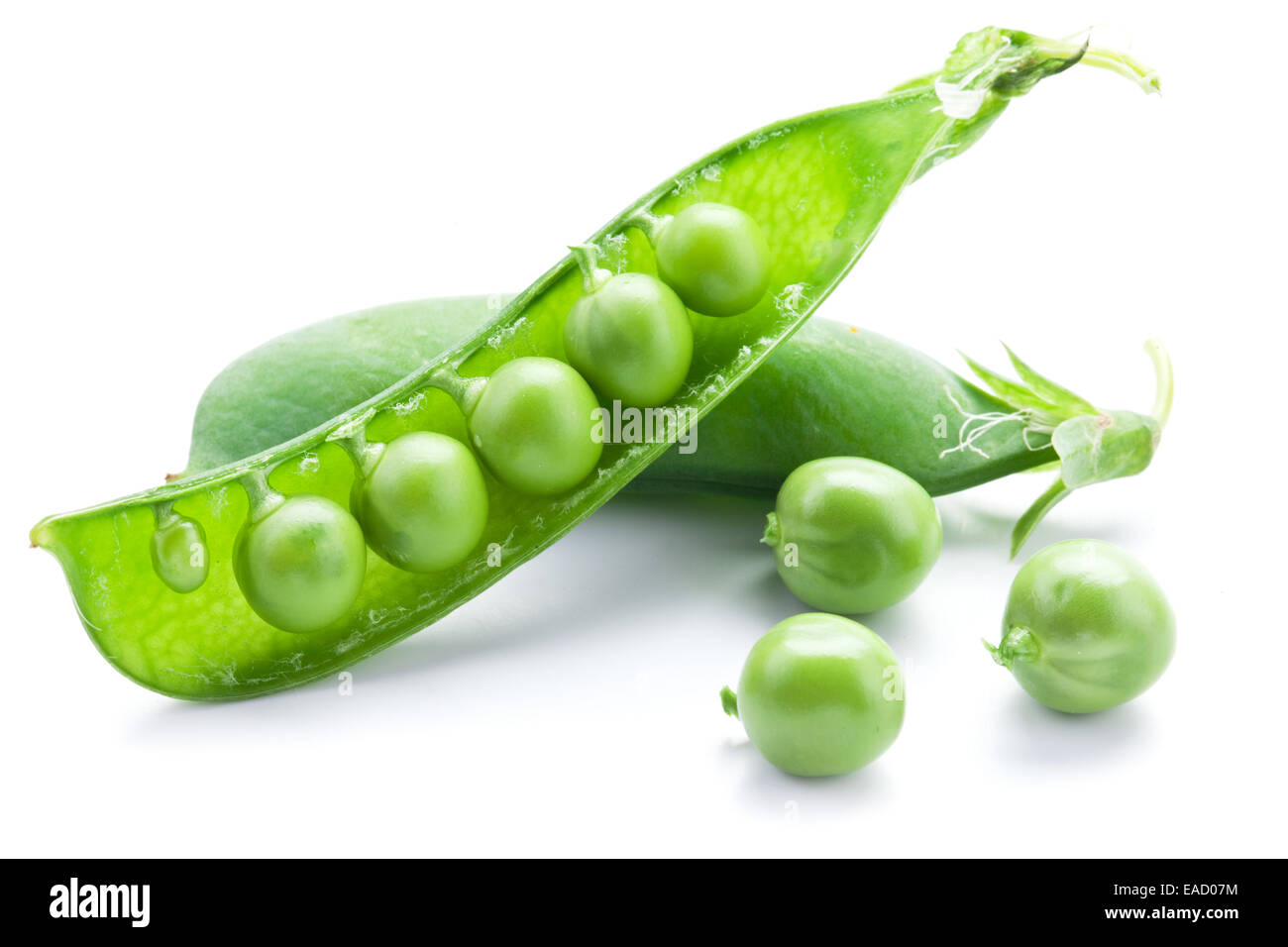 Fresh peas are contained within a pod isolated on a white background. Stock Photo