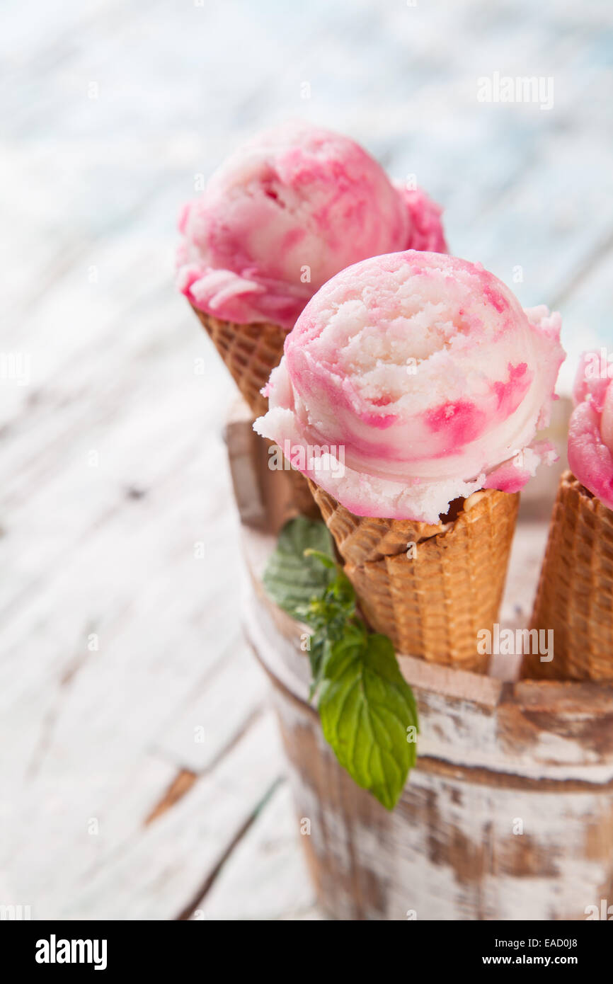 Studio photo of ice cream scoops in waffle cones. Served on wooden ...