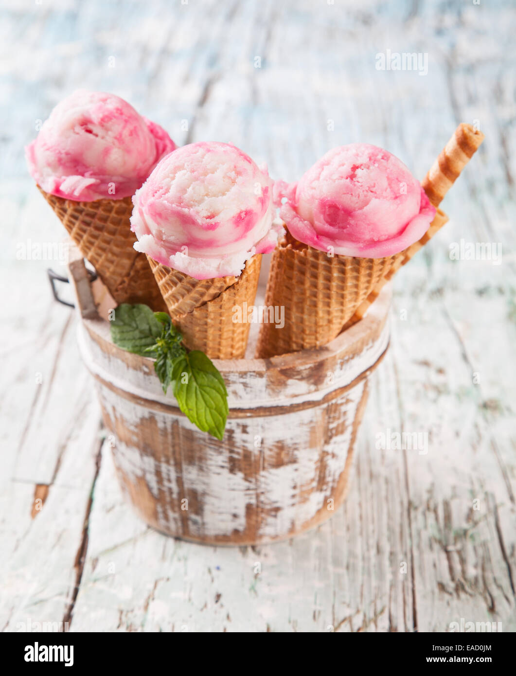 Studio photo of ice cream scoops in waffle cones. Served on wooden ...