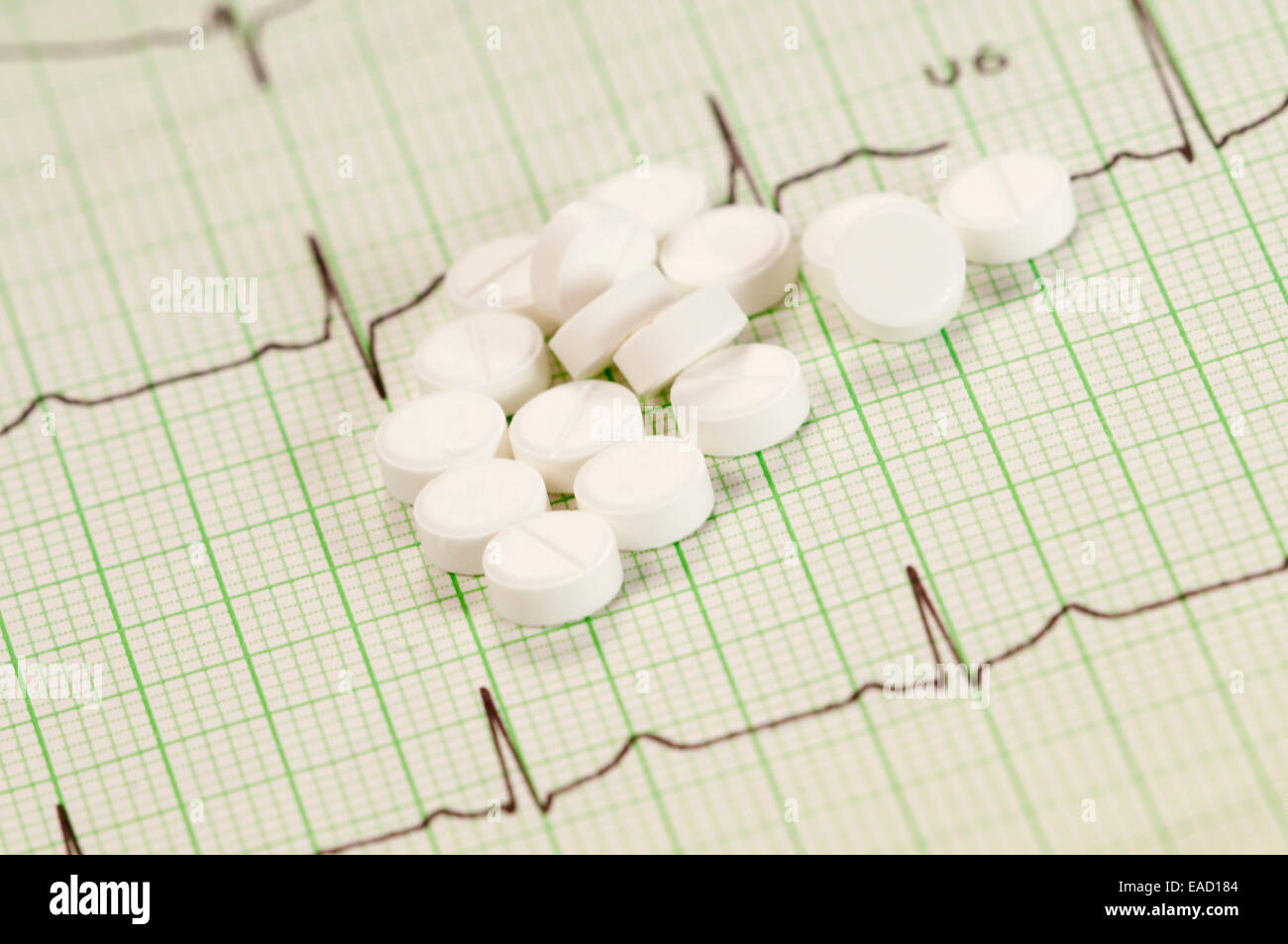 Tablets on electrocardiogram paper, closeup shot, local focus Stock Photo