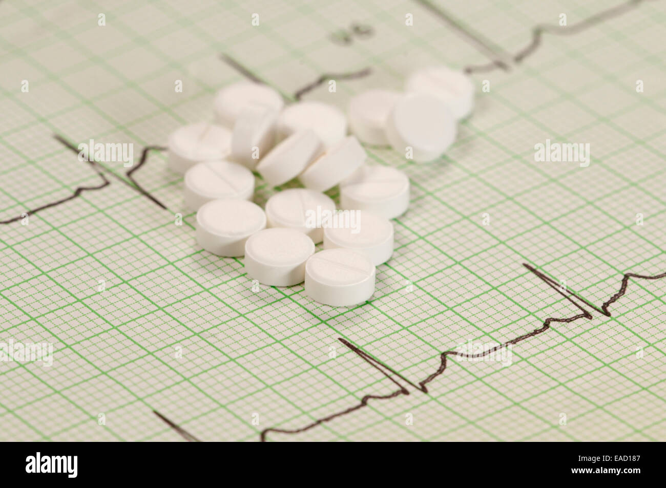 Tablets on electrocardiogram paper, closeup shot, local focus Stock Photo