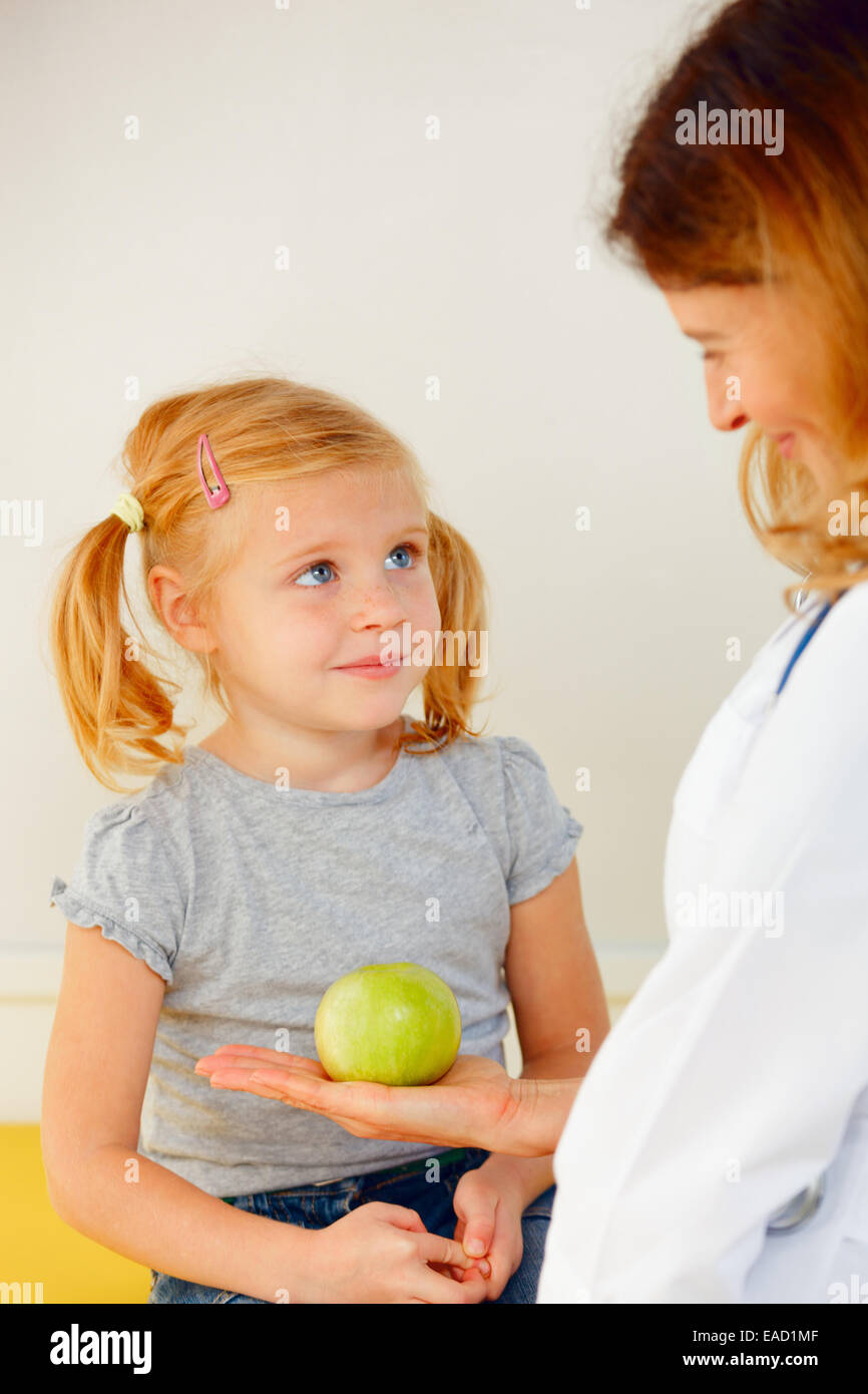 Doctor giving green apple to small patient Stock Photo Alamy