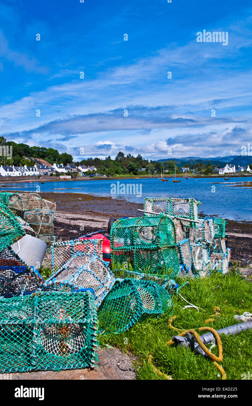 Lobster creels and fishing gear stacked above the tide line in Plockton harbour on Loch Carron, Wester Ross, Scottish Highlands Stock Photo