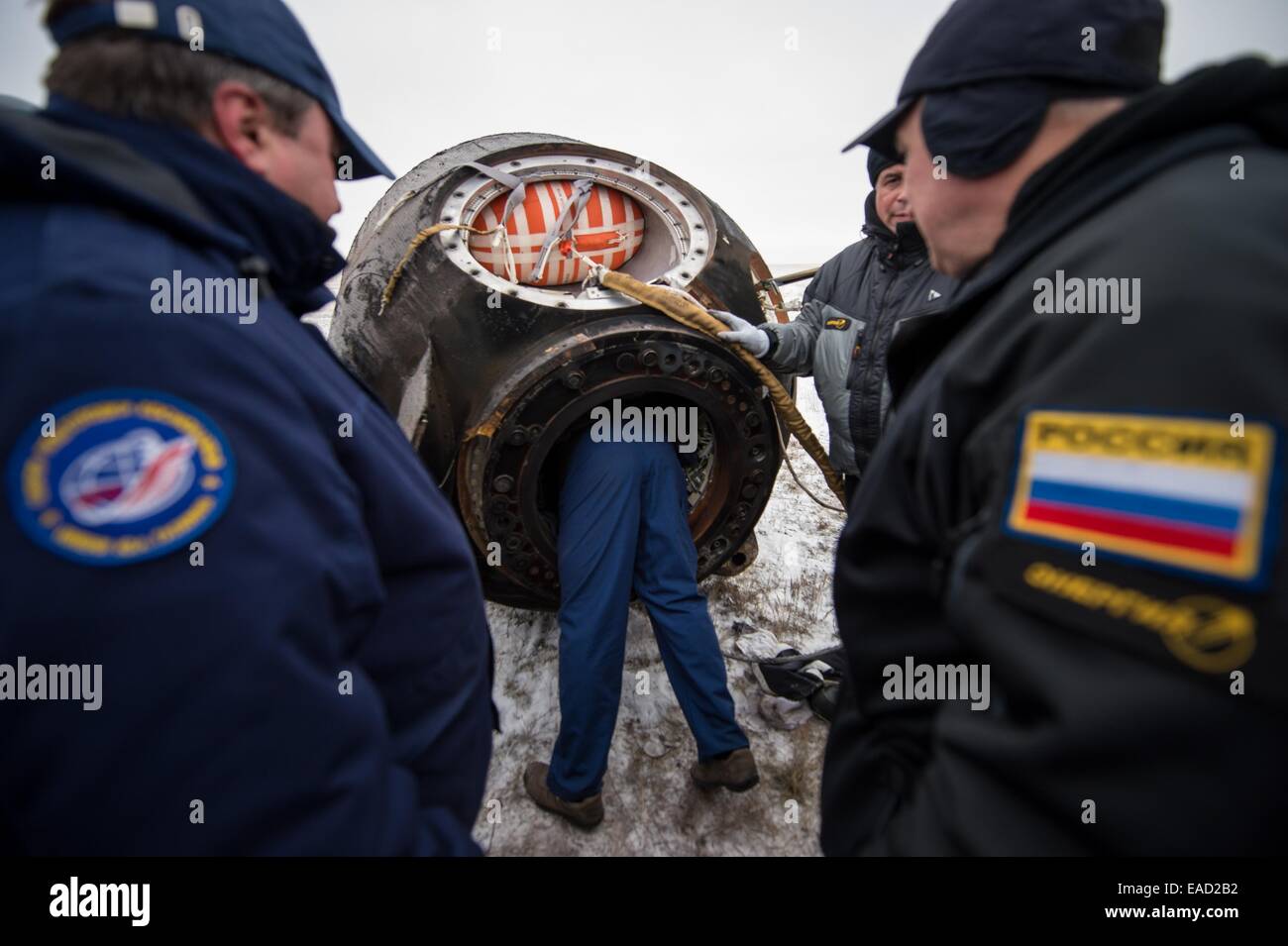 Russian Federal Space Agency ground personnel work to extract ISS Expedition 41 crew from the Soyuz TMA-13M space capsule just minutes after they landed in a remote area November 10, 2014 near Arkalyk, Kazakhstan. Suraev, Wiseman and Gerst returned to Earth after more than five months onboard the International Space Station where they served as members of the Expedition 40 and 41 crews. Stock Photo