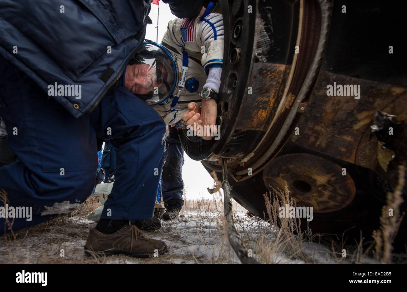 ISS Expedition 41 astronaut Reid Wiseman of NASA is helped out of the Soyuz Capsule just minutes after landing in a remote area November 10, 2014 near Arkalyk, Kazakhstan. Suraev, Wiseman and Gerst returned to Earth after more than five months onboard the International Space Station where they served as members of the Expedition 40 and 41 crews. Stock Photo