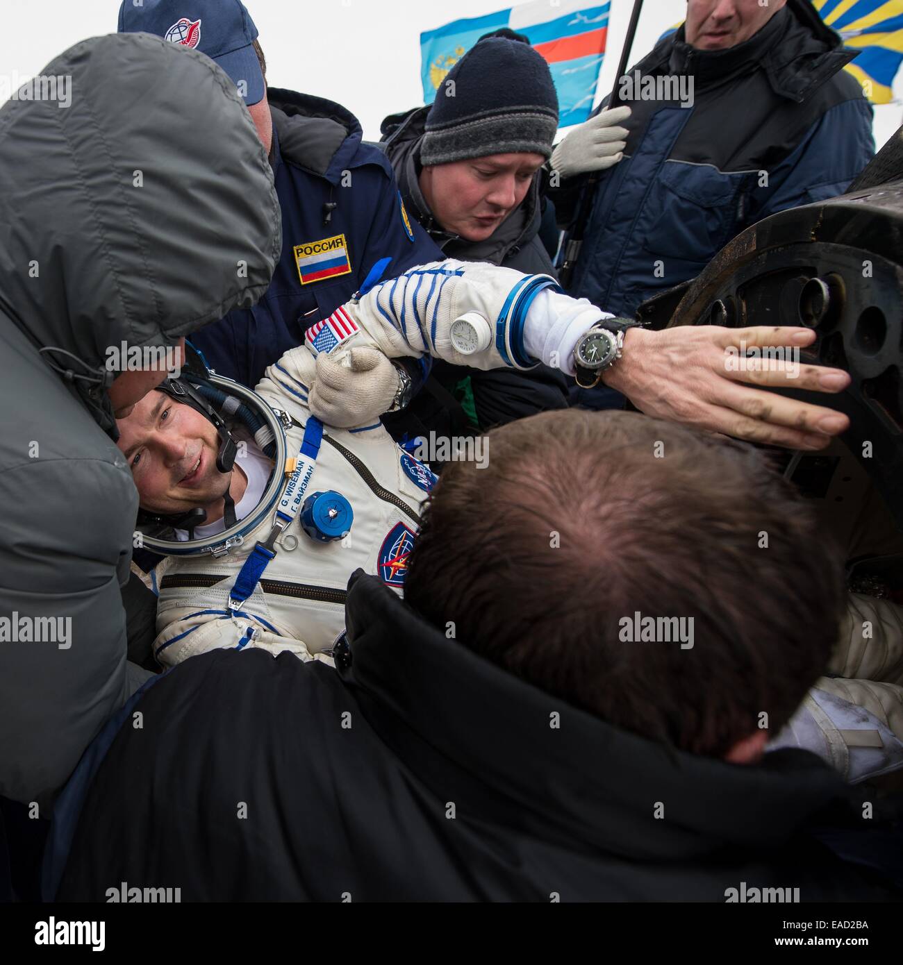 ISS Expedition 41 astronaut Reid Wiseman of NASA is helped out of the Soyuz Capsule just minutes after landing in a remote area November 10, 2014 near Arkalyk, Kazakhstan. Suraev, Wiseman and Gerst returned to Earth after more than five months onboard the International Space Station where they served as members of the Expedition 40 and 41 crews. Stock Photo
