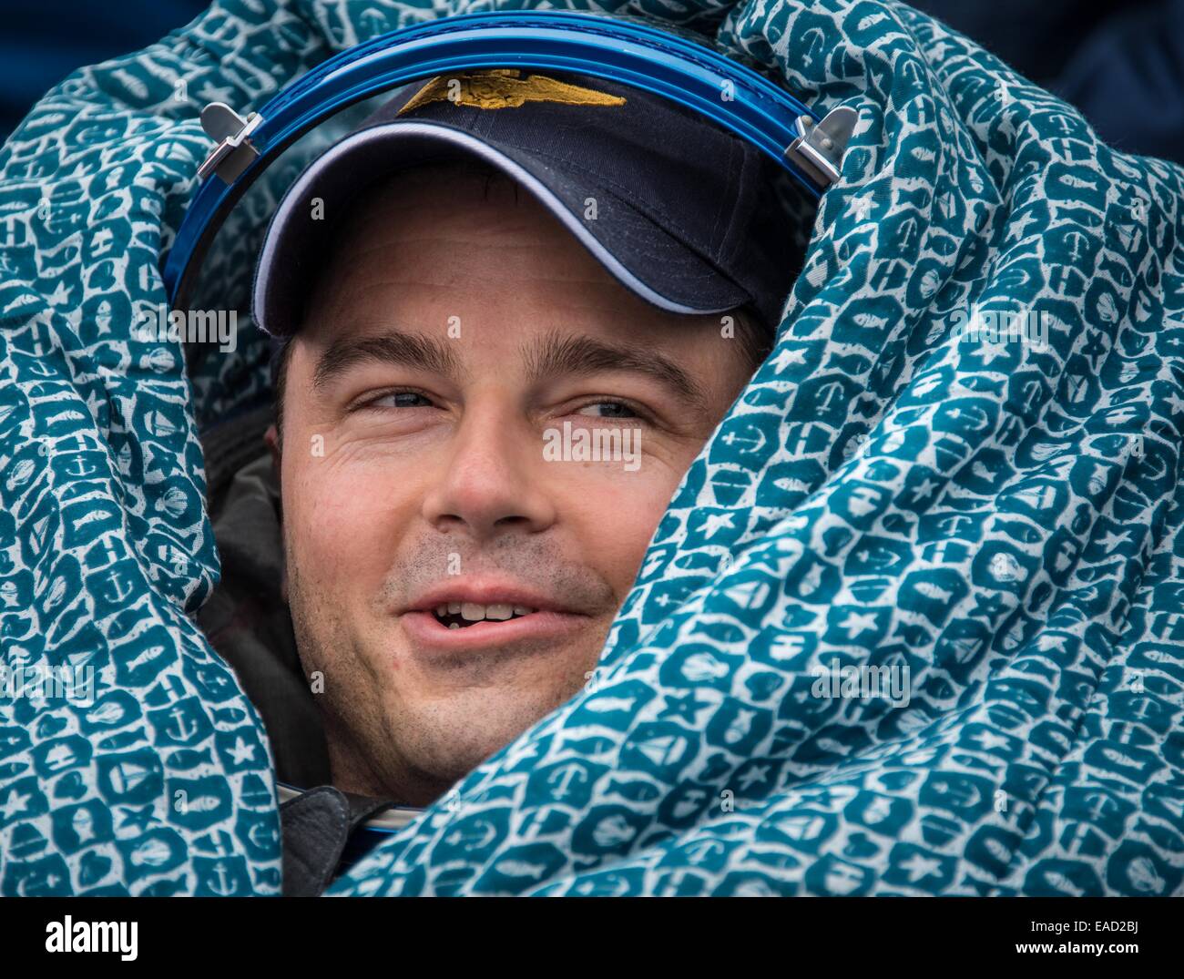 ISS Expedition 41 astronaut Reid Wiseman of NASA sits outside the Soyuz Capsule just minutes after landing in a remote area November 10, 2014 near Arkalyk, Kazakhstan. Suraev, Wiseman and Gerst returned to Earth after more than five months onboard the International Space Station where they served as members of the Expedition 40 and 41 crews. Stock Photo