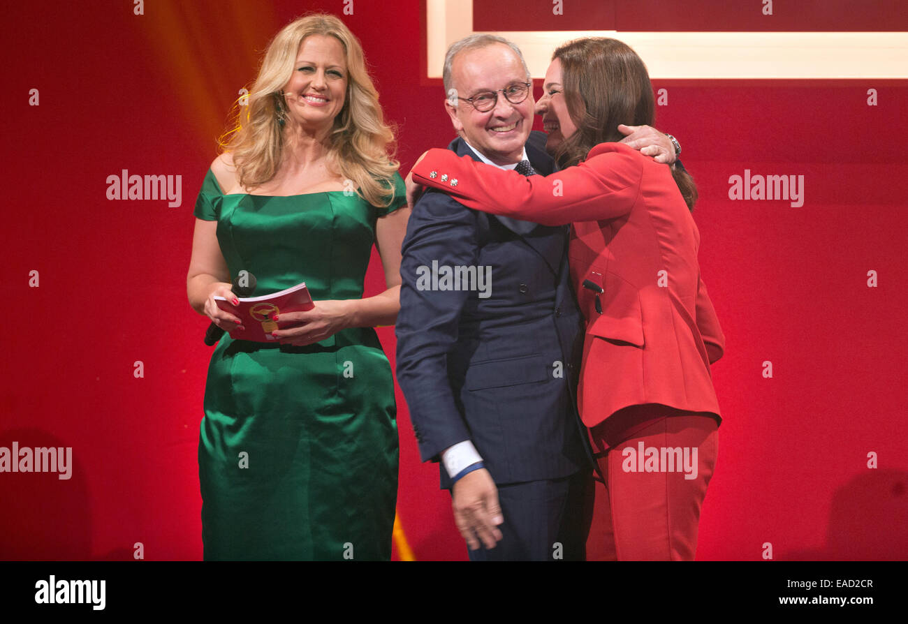 Berlin, Germany. 11th Nov, 2014. Chief designer at Volkswagen, Walter de'Silva, receives from hosts Barbara Schoeneberger (L) and Desiree Nosbush the award in 'Middle/Luxury Class' for the VW Passat at the Golden Steering Wheel 2014 award ceremony in Berlin, 11 November 2014. Credit:  dpa picture alliance/Alamy Live News Stock Photo