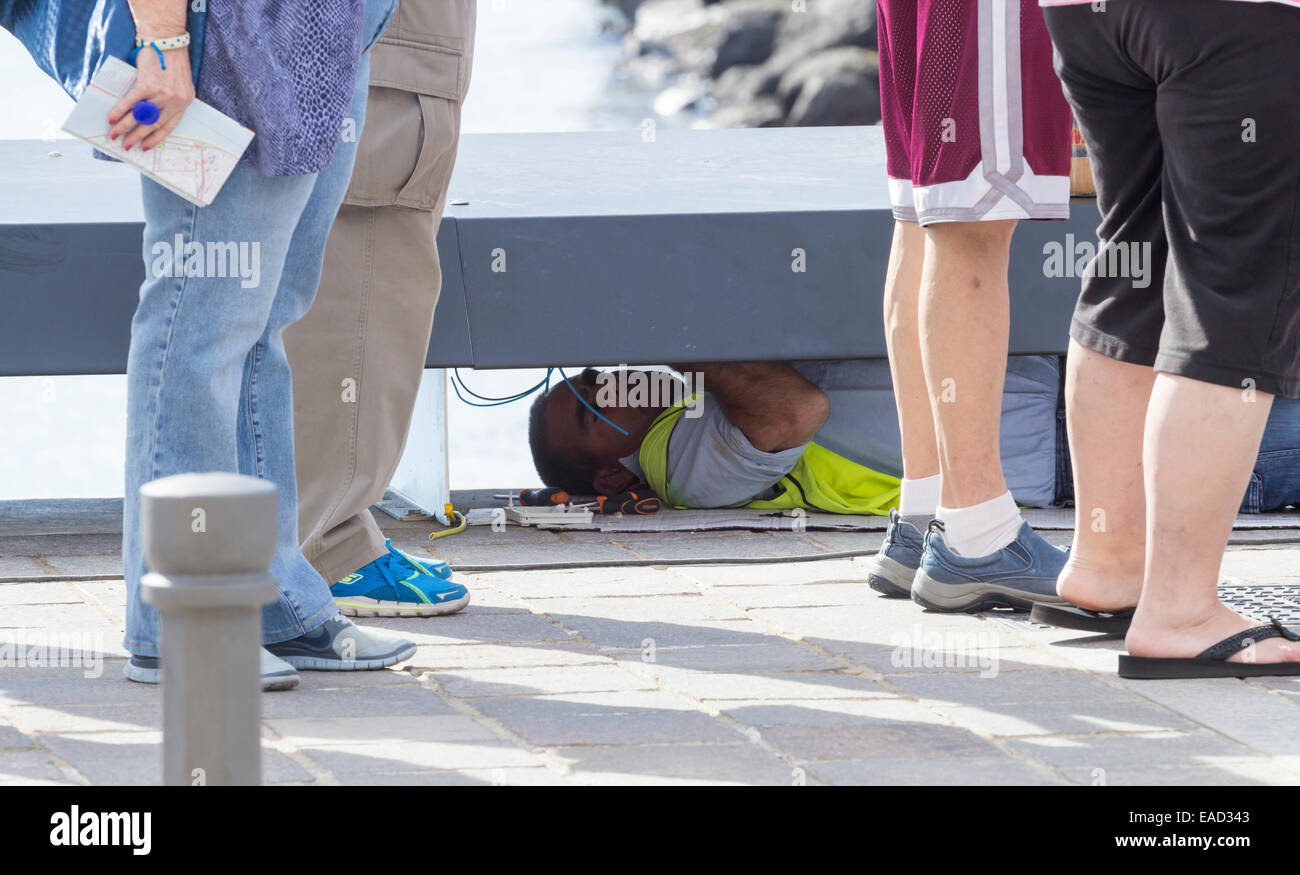 Workman lighting cables underseafront benches as tourists queue for ...