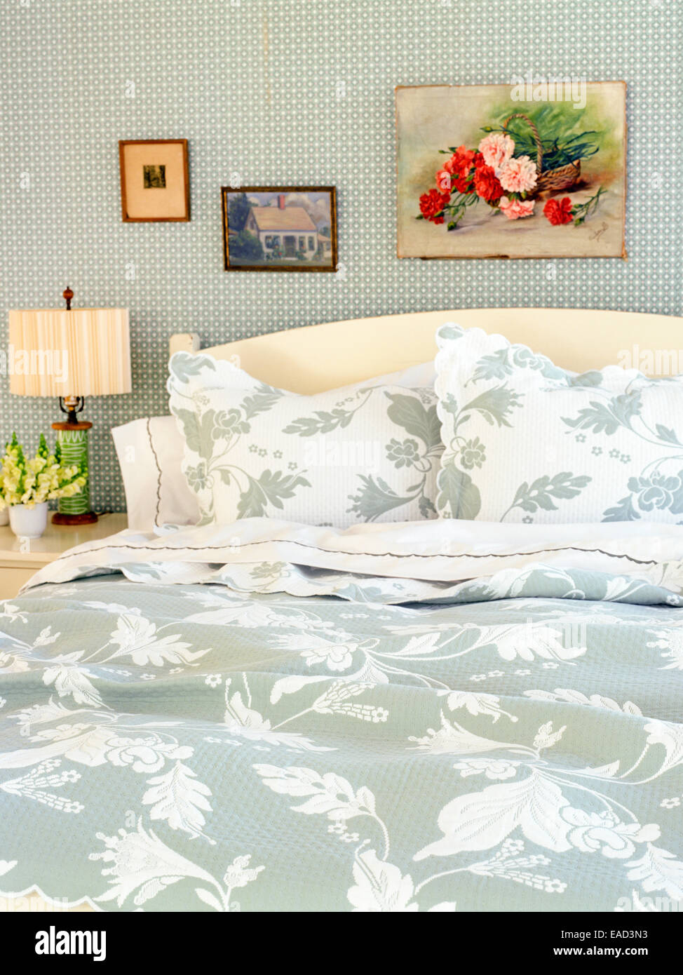 Bed with floral patterned blankets and pillows Stock Photo