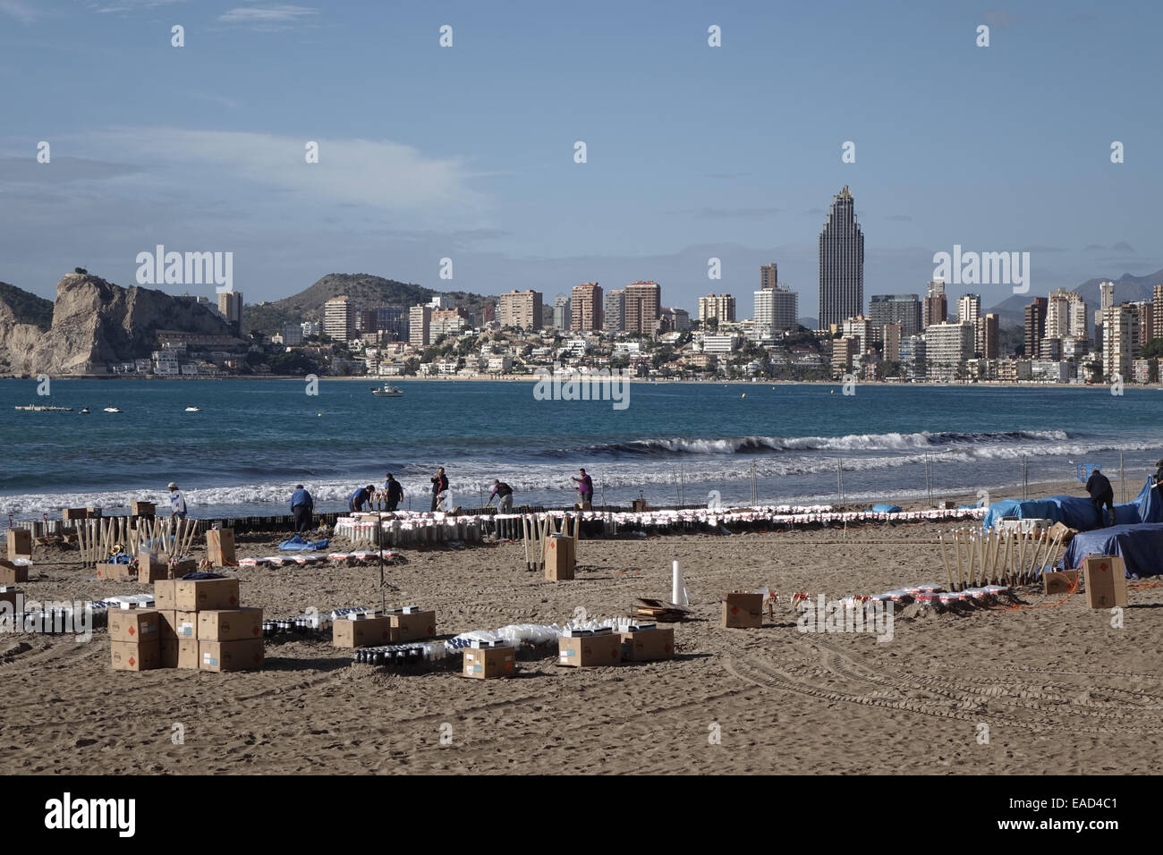 Benidorm, Spain. 12th November, 2014. The preparations for the final, gigantic fireworks spectacular of the Fiesta which happens tonight at 9pm are taking place in clear sunny weather on Poniente beach in Benidorm. Hundreds of explosive charges and mortar tubes which contain the larger fireworks are visible on the tourist beach which is fenced off for the popular event. Credit:  Mick Flynn/Alamy Live News Stock Photo