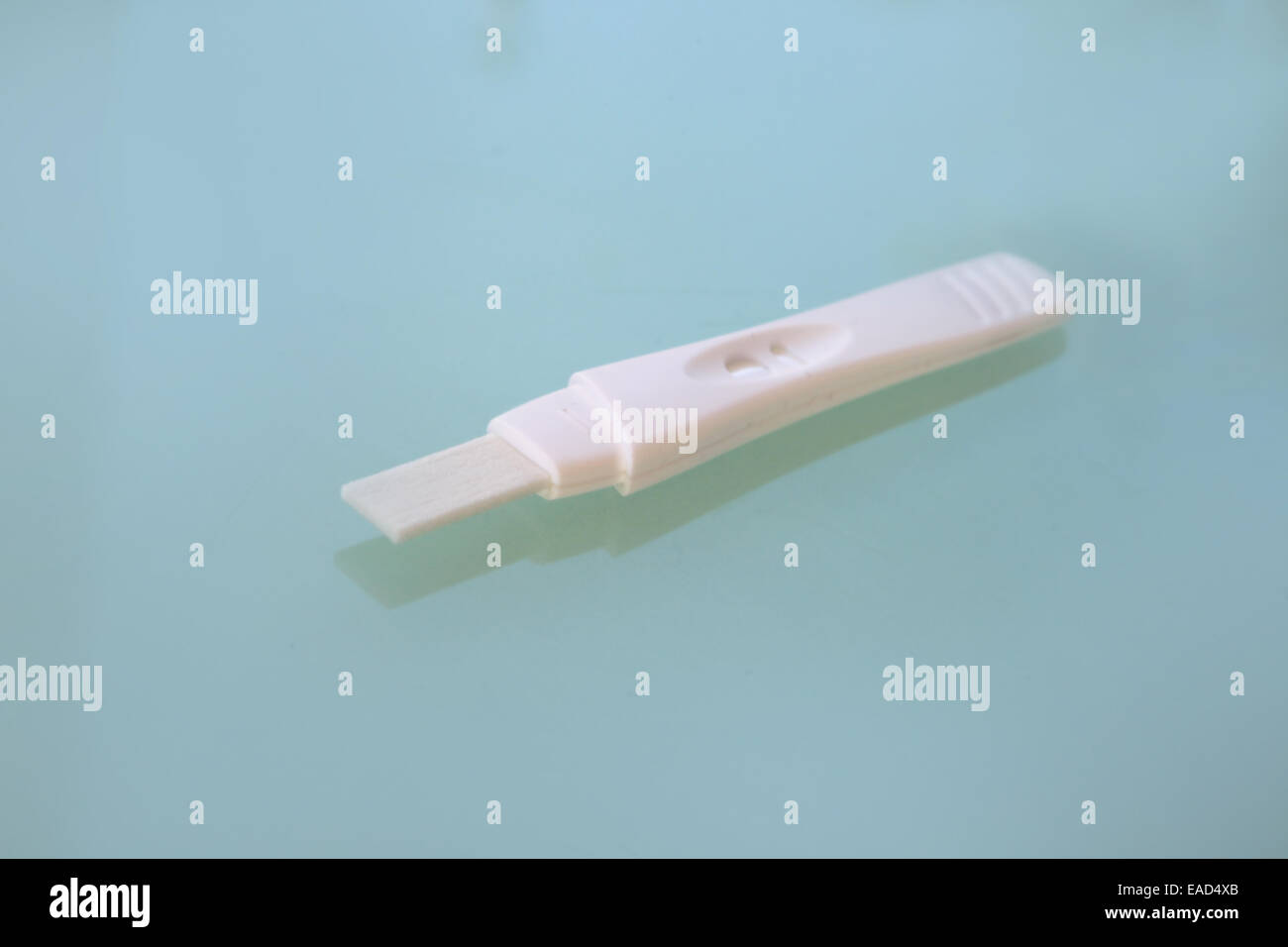 Pregnancy testing stick on a green table top. Stock Photo