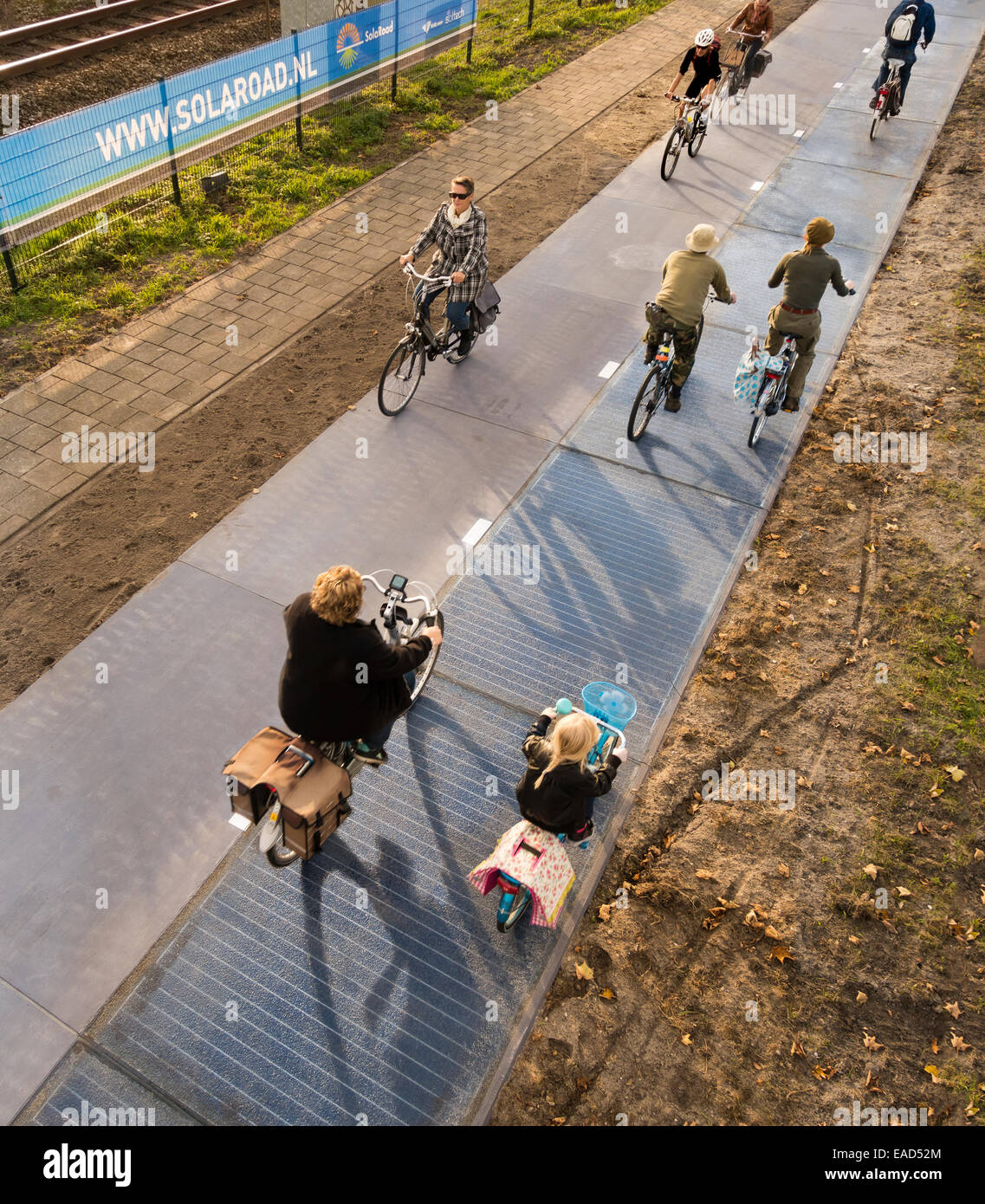 Krommenie, Netherlands. 12th November, 2014. File photo: November 1st 2014. World's first cycle lane made from solar cells with cyclists on busy bike path. Initially only 70 meters (230ft) long. Installed October 2014 in Krommenie, 25 km (15 miles) north of Amsterdam. Made from concrete slabs of 2.5 by 3.5 meters ( 6.5x10ft) with a translucent top layer of tempered glass, which is about 1cm thick. Underneath the glass are crystalline silicon solar cells. The initial stretch is capable of producing enough energy to power three homes. Credit:  Wiskerke/Alamy Live News Stock Photo