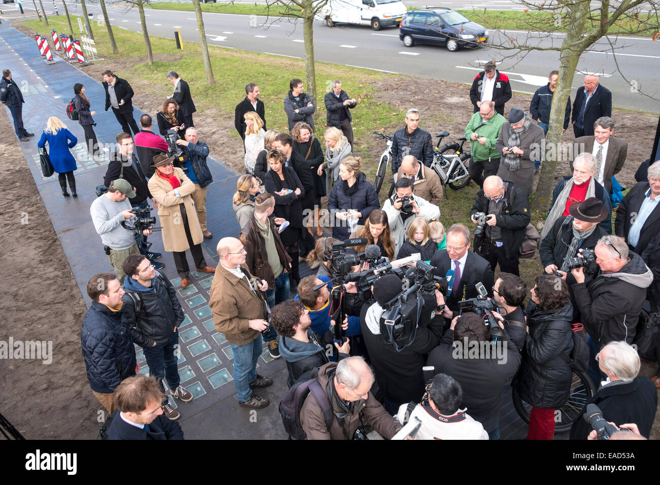 Krommenie, Netherlands. 12th November, 2014. Dutch Minister of Economic Affairs Henk Kamp has just opened the world's first bicycle lane made from solar cells in Krommenie, 25 kilometers north of Amsterdam. On a bike. Normally the opening of a cycle track is strictly a local affair in the Netherlands. This one is special: only 70 meters (230ft) long, it's the world's first bicycle lane made from solar cells. Now local and foreign press  (German, Russian, Chinese among them) all want his comment. Credit:  Wiskerke/Alamy Live News Stock Photo