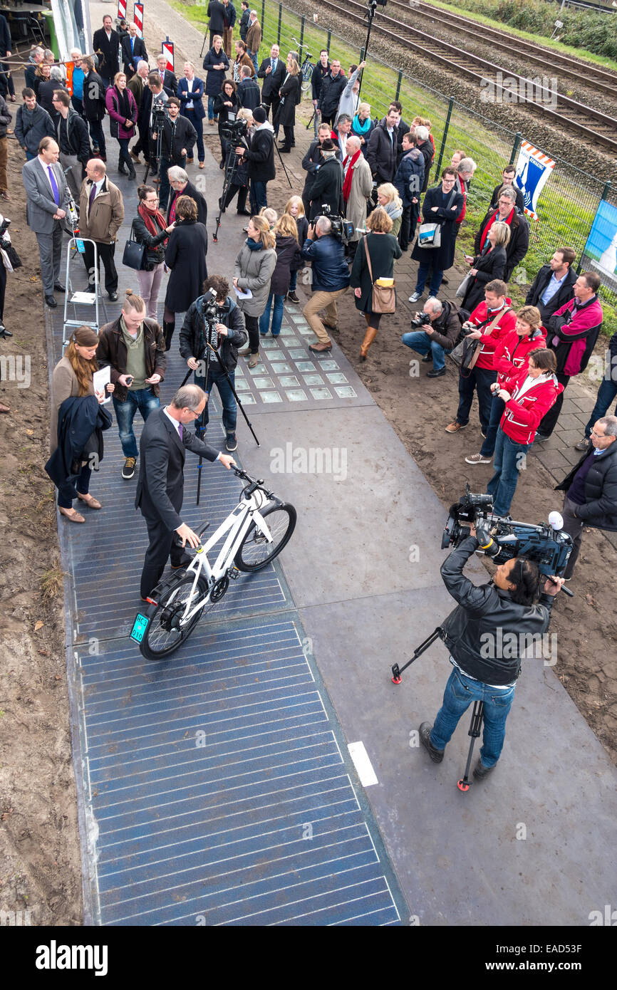 11/2014 Dutch Minister of Economic Affairs Henk Kamp opens the world's first bicycle lane made from solar cells in Krommenie, 25 kilometers north of Amsterdam. Normally the opening of a cycle track is strictly a local affair in the Netherlands. This one is special: only 70 meters (230ft) long, it's the world's first bicycle lane made from solar cells.  Constructed of concrete slabs of 2.5 by 3.5 meters ( 6.5x10ft) with a translucent top layer of tempered glass with crystalline silicon solar cells underneath, it can produce enough energy to power three homes. Stock Photo