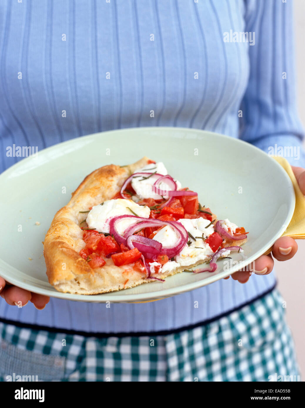 woman holding plated pizza slice Stock Photo