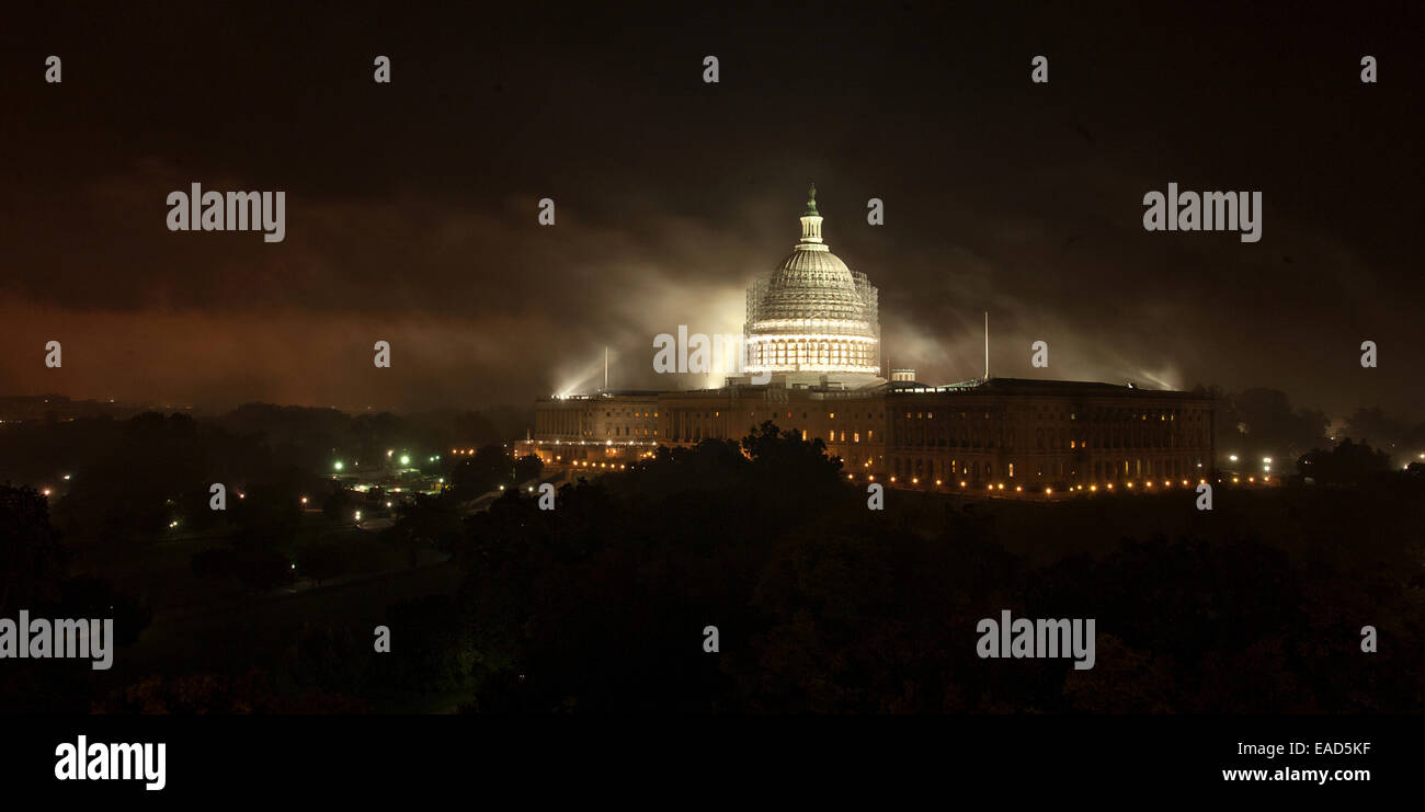 The US Capitol Dome surrounded by scaffolding illuminated on a foggy night November 10, 2014 in Washington, DC. The $60 million dollar project is to stop the deterioration of the cast iron dome and preserve it for the future.  Stock Photo