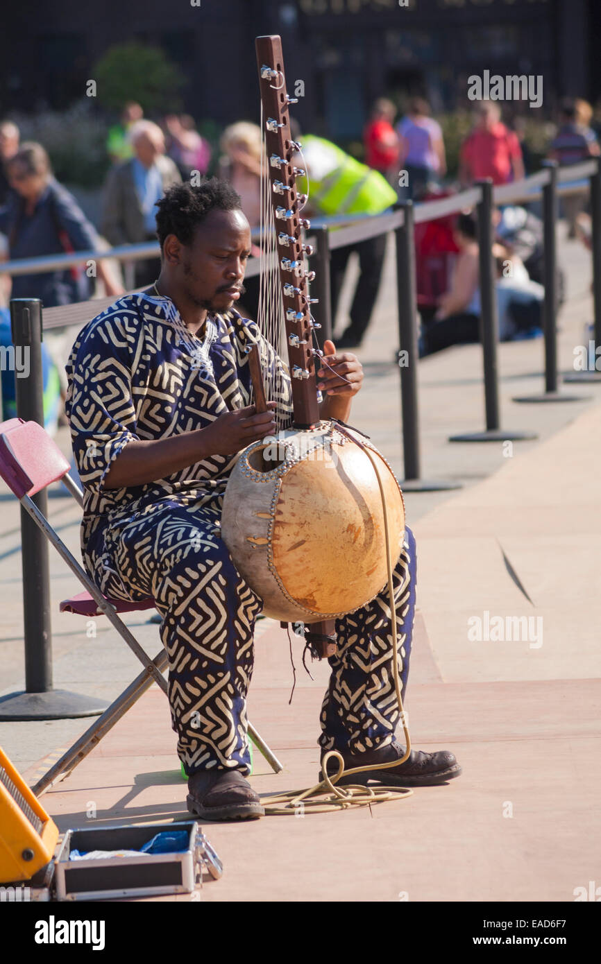 Man playing Kora, or Cora, an African stringed musical instrument at