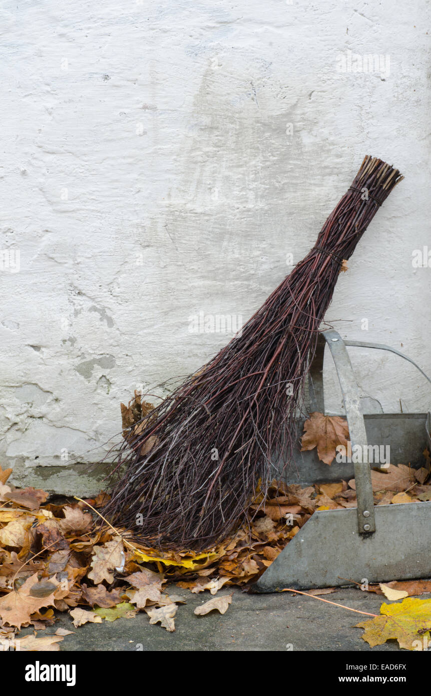 chores in garden with old  wicker broom Stock Photo