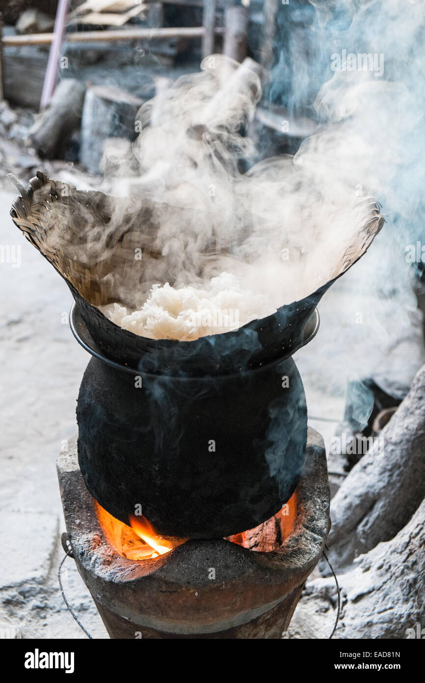 Pot of boiling hot steamed rice being cooked on an open coal fire ...