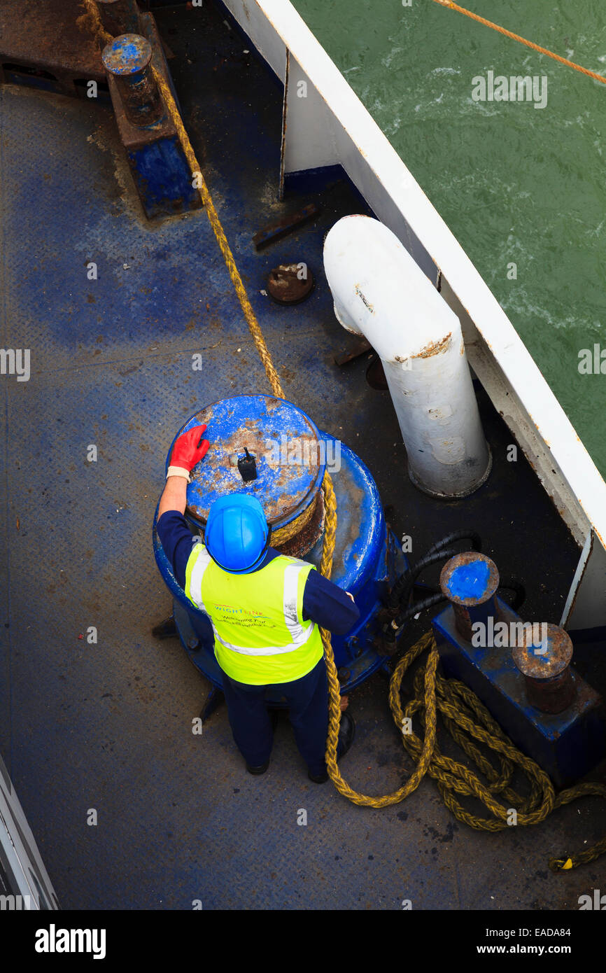 Looking down on crew member using mooring rope winding winch Stock Photo