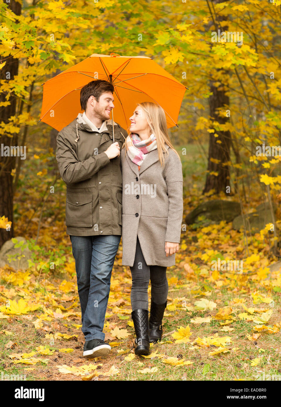 smiling couple with umbrella in autumn park Stock Photo - Alamy