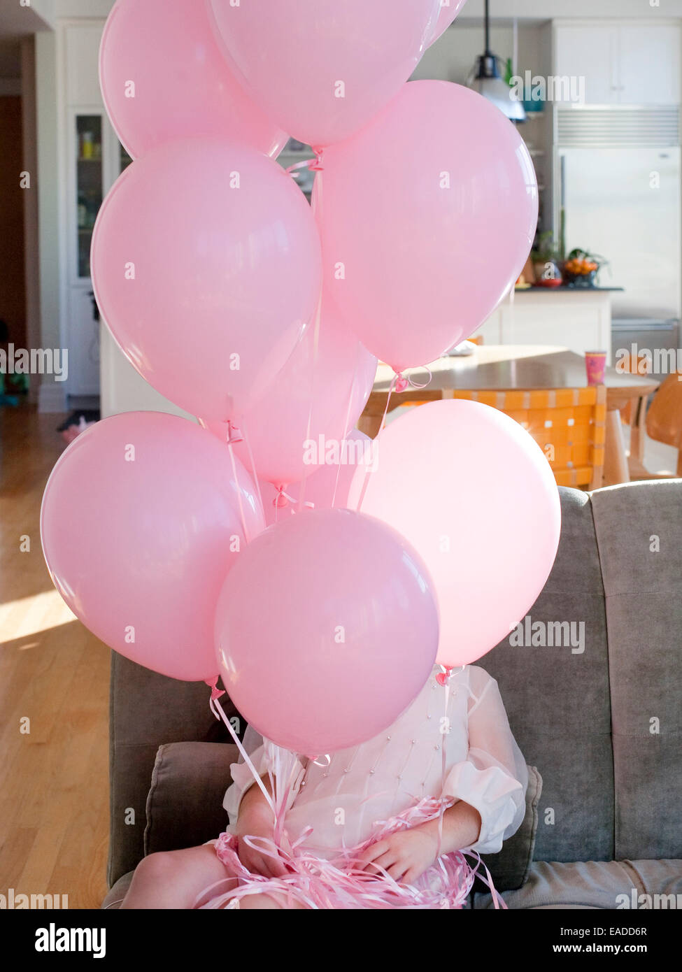 girl in pink party dress holding pink balloons Stock Photo