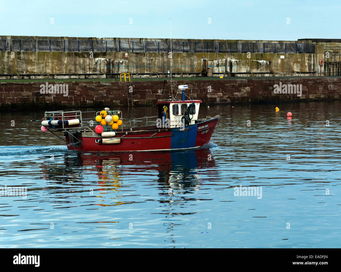 A small fishing boat arriving back into harbour Stock Photo - Alamy