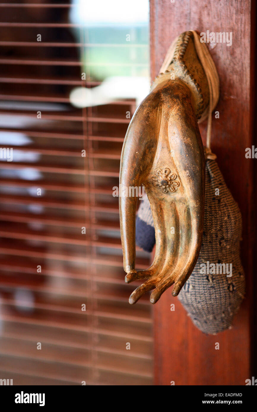Gilded door handle on a dark wood door with glass with a lavender sachet Stock Photo