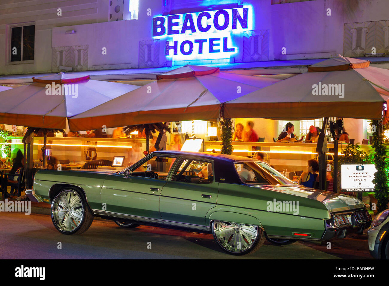 Miami Beach Florida,Ocean Drive,dusk,evening,night,palm trees,Beacon,hotel,buildings,neon,traffic,pimped classic car,customized,restaurant restaurants Stock Photo