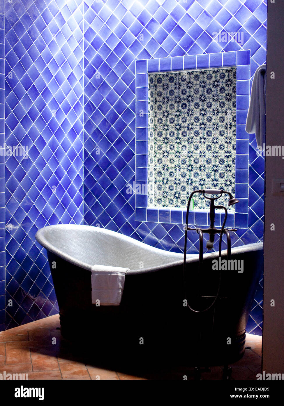 Metal Bath tub In Blue Tiled  Bathroom Stock Photo
