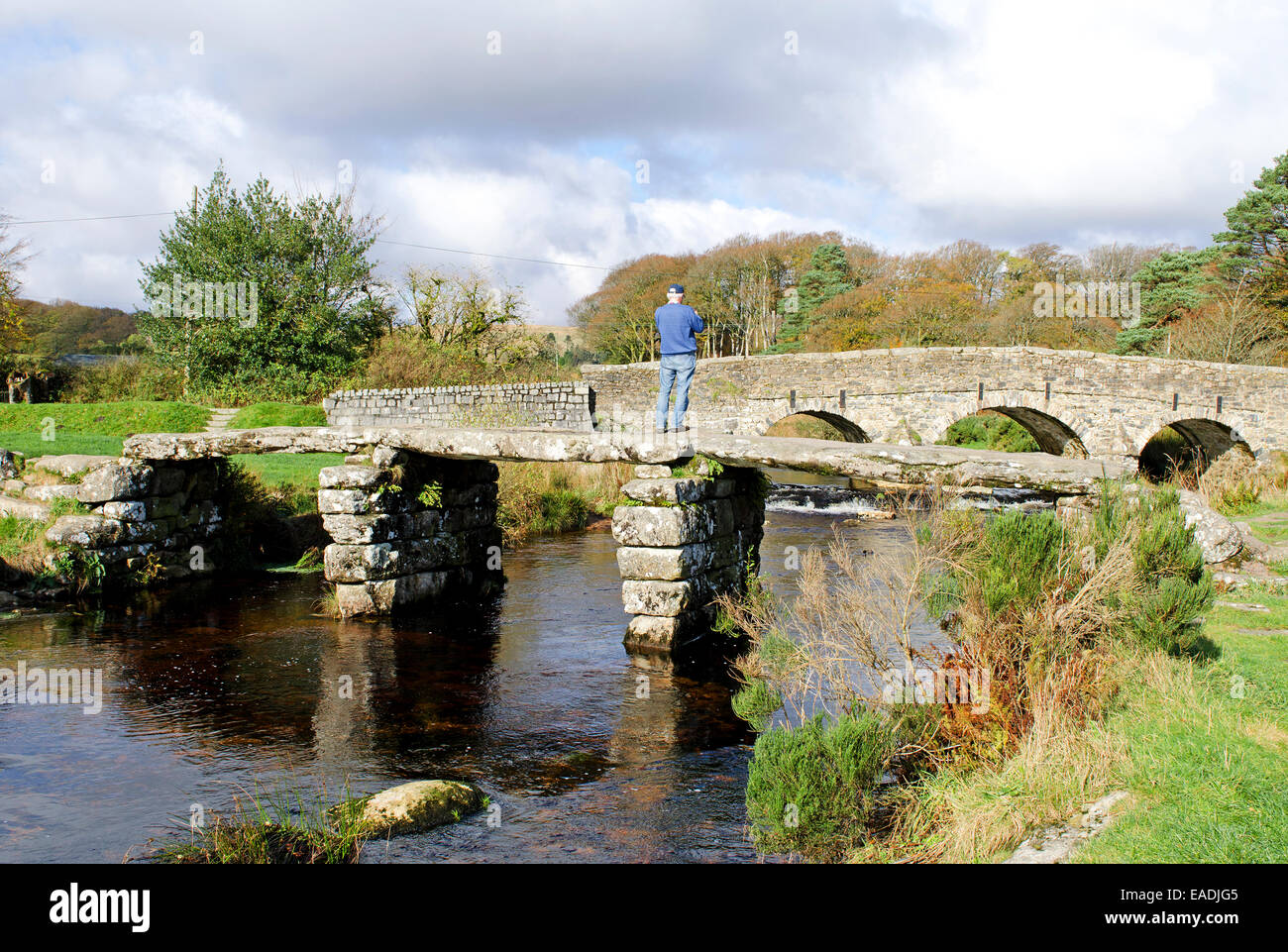 The old Clapper bridge crosses the East Dart river in the village of Postbridge on Dartmoor, Devon, UK Stock Photo