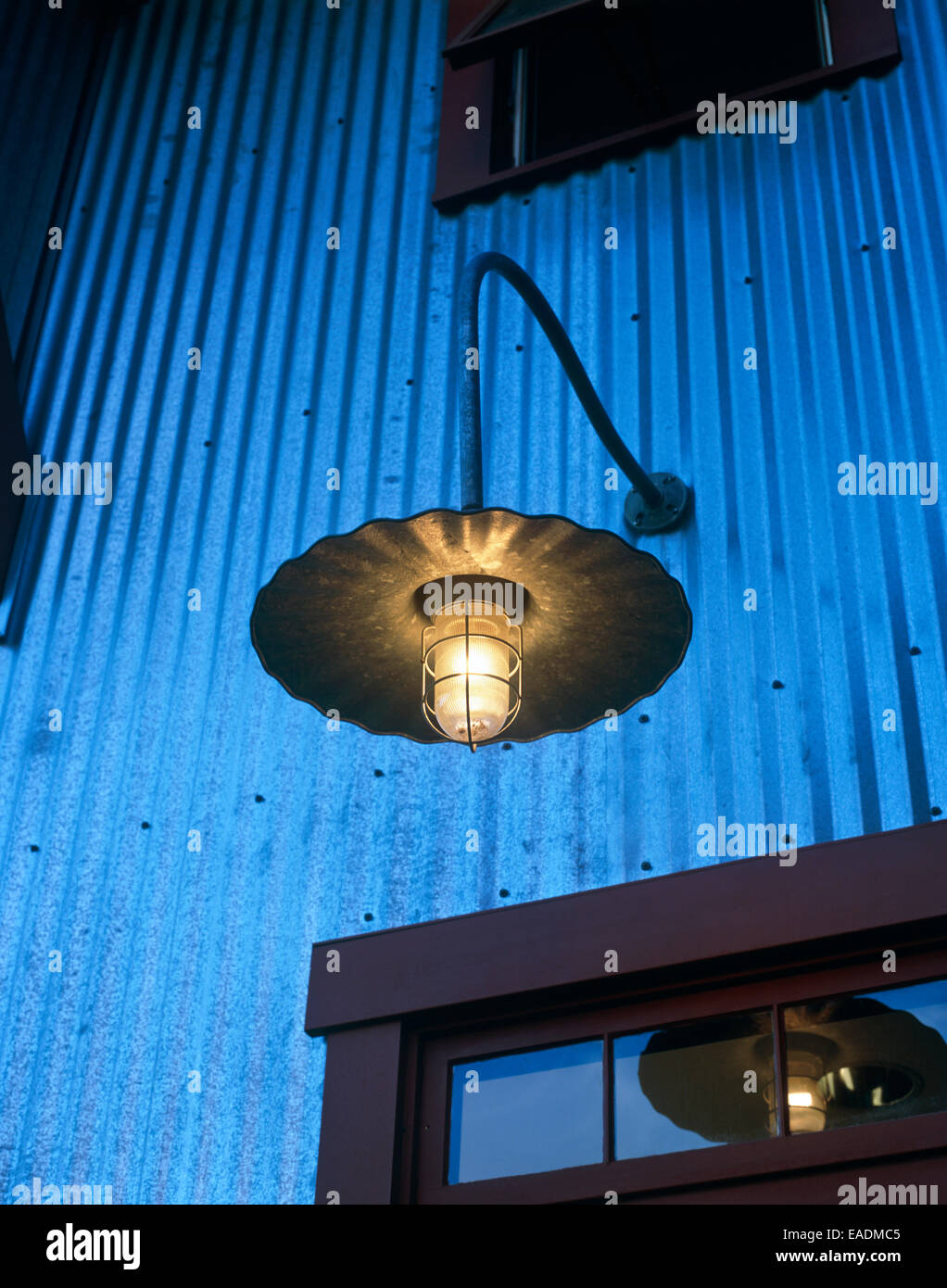 detail of contemporary country style outdoor light above entrance way at dusk Stock Photo