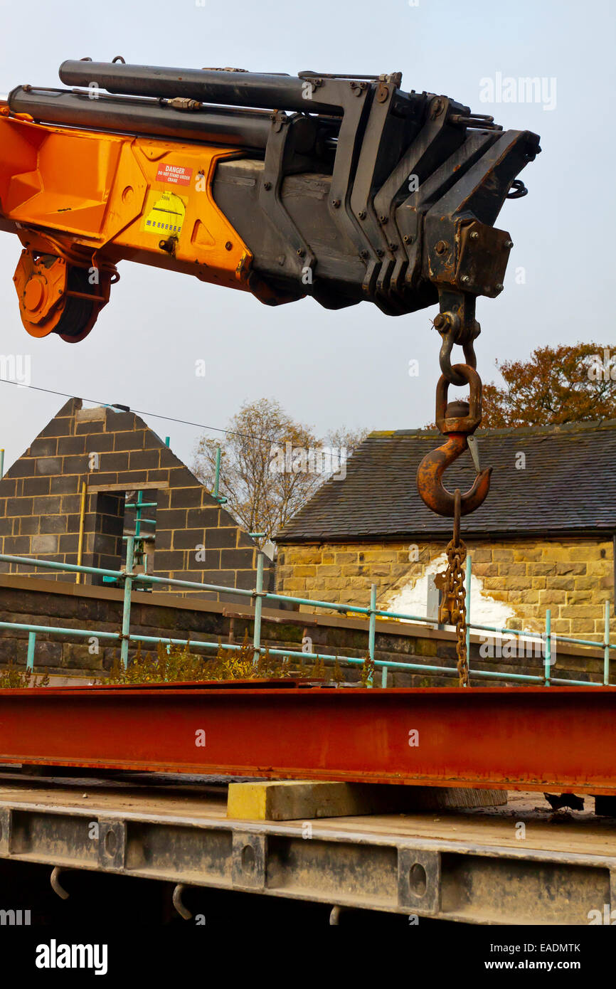 Extendable crane being used to lift materials from the back of a lorry on a building site Stock Photo