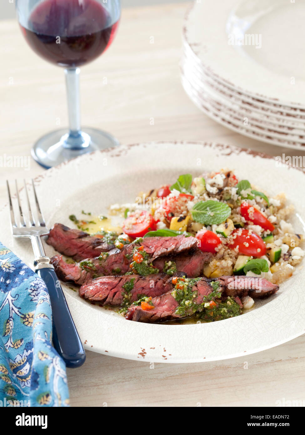 Grilled Beef and Couscous salad with glass of red wine. Stock Photo
