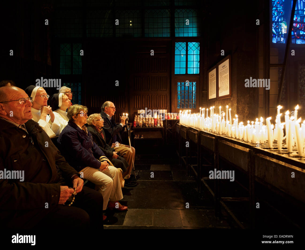 People praying after lighting candles at the Basilica of Our Lady in
