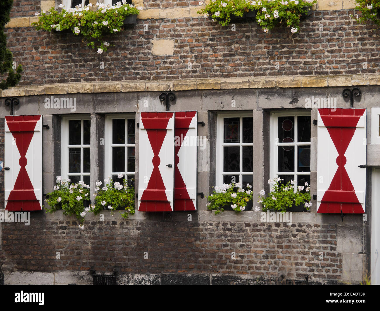 Wood window shutters painted red and white on a building in Maastricht