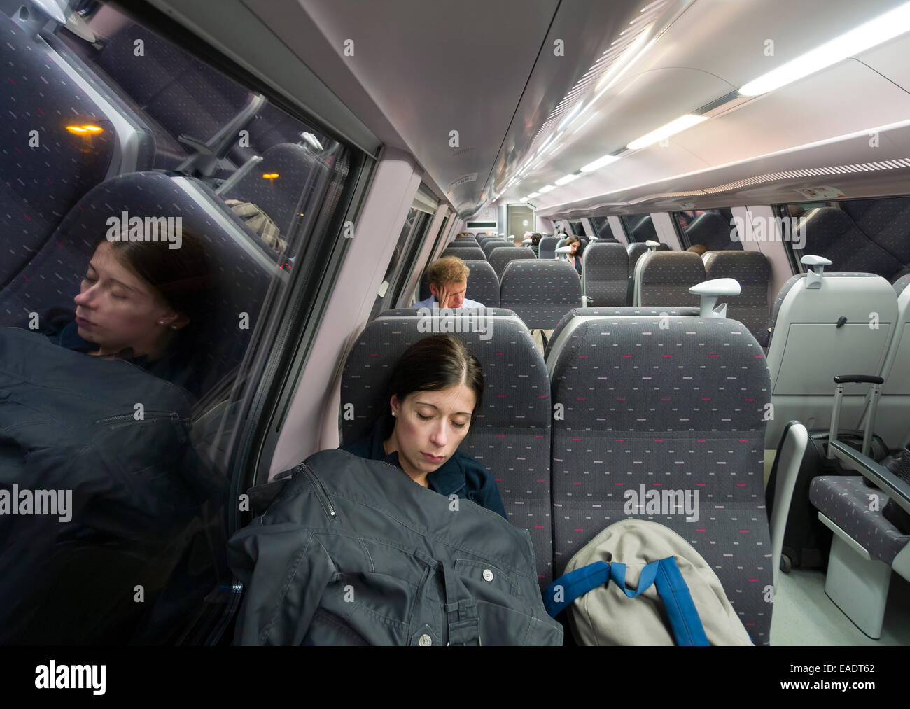 Young woman asleep on train Stock Photo