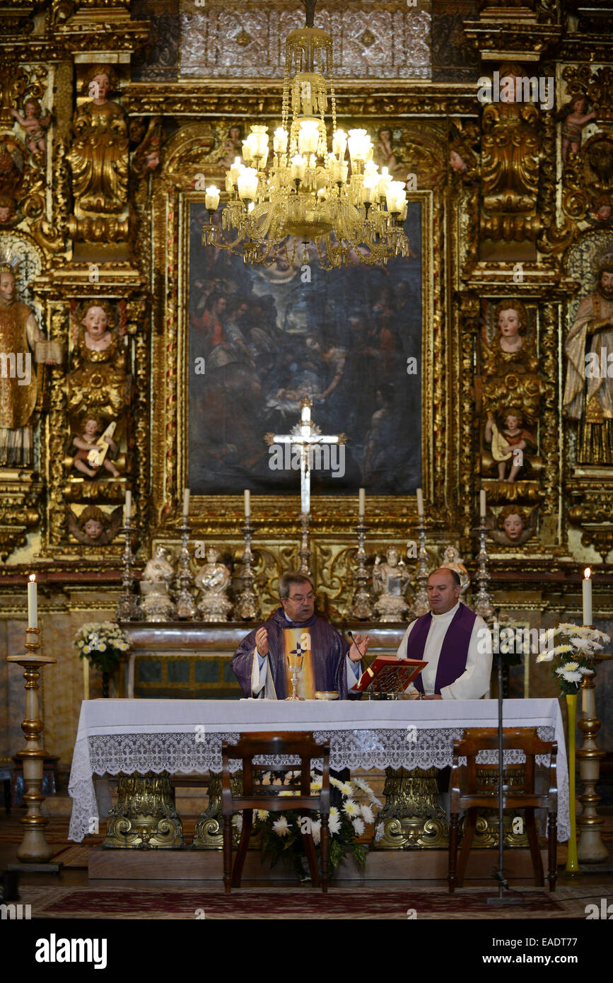 Priest celebrating catholic mass in front of the church altar Stock Photo